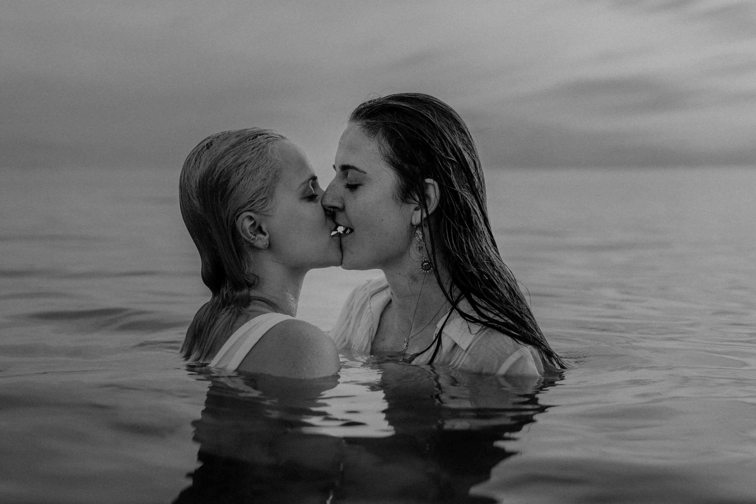lesbisches Paar küsst sich im Wasser